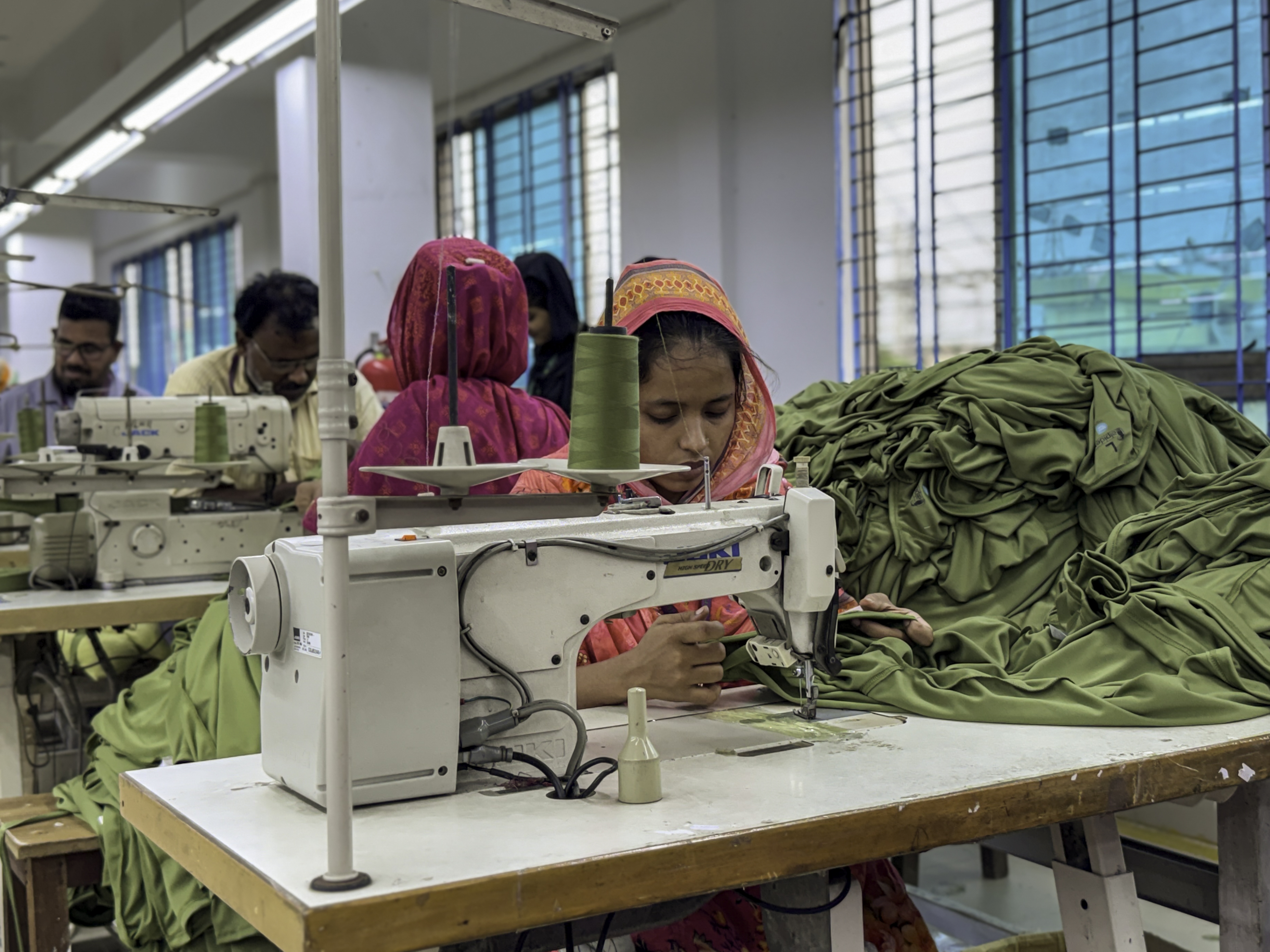 Workers at sewing machines on the production floor