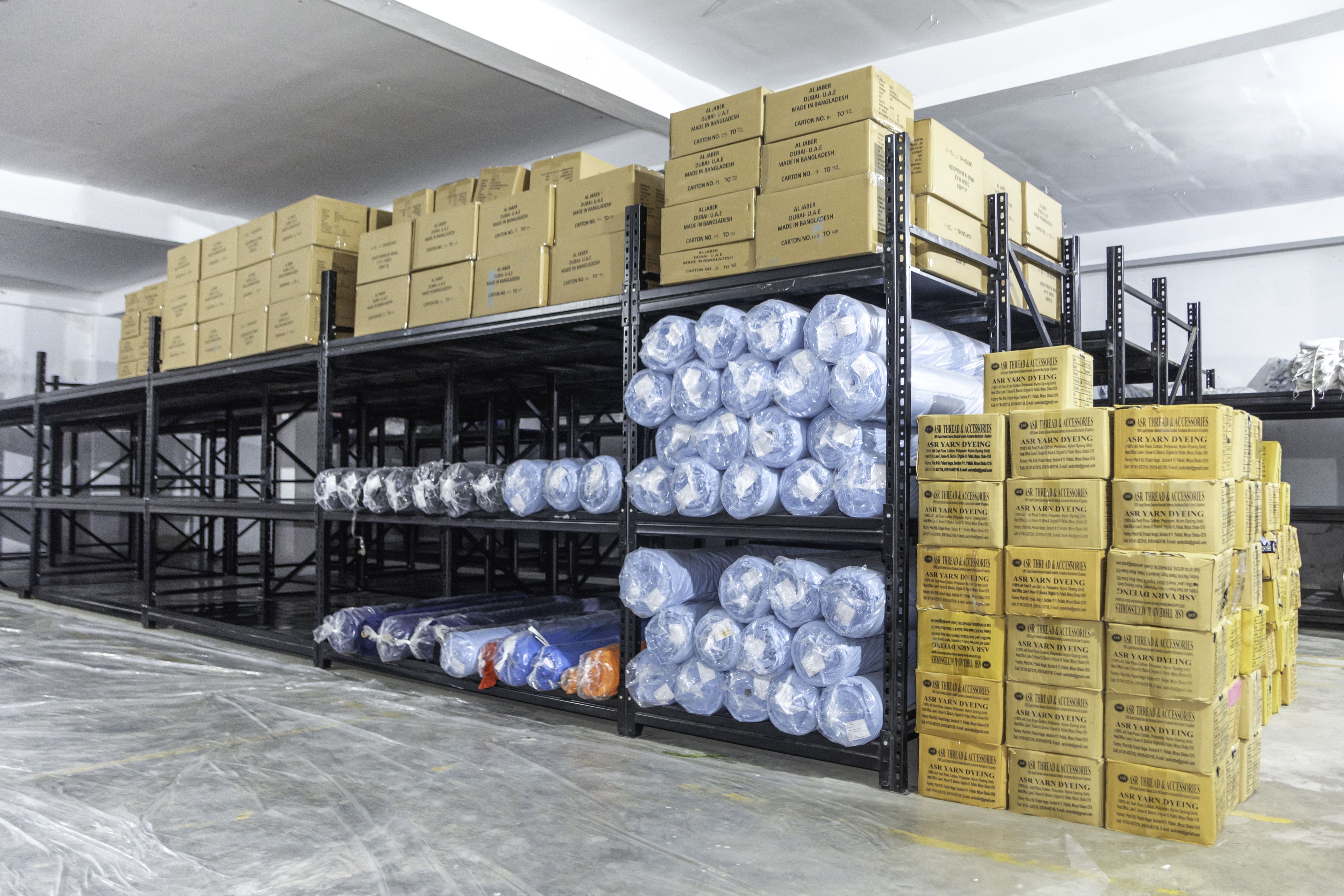 Warehouse with fabric rolls and packed export cartons on shelving